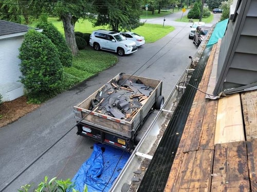 dump trailer full of roof debris from tearing off old roof