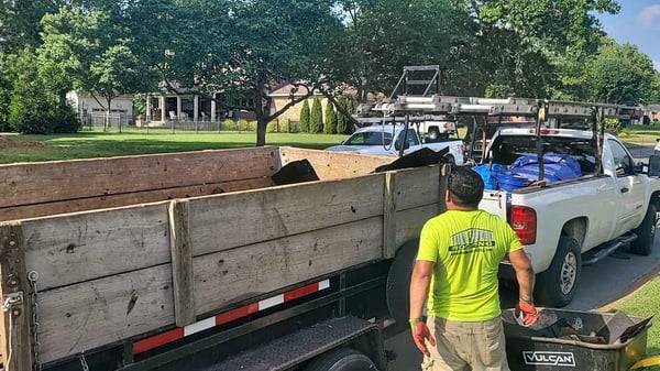 dumping roofing debris into a dump trailer