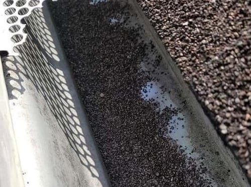 asphalt granules in gutter