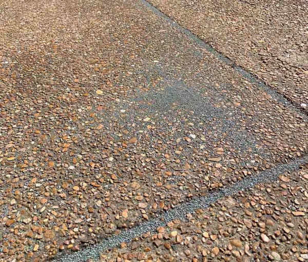 asphalt granules on the ground by downspouts