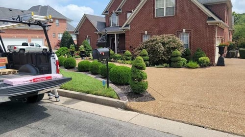 bundle of shingles in truck with mailbox and home in the background