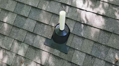 inspecting a plumbing vent during a roof inspection