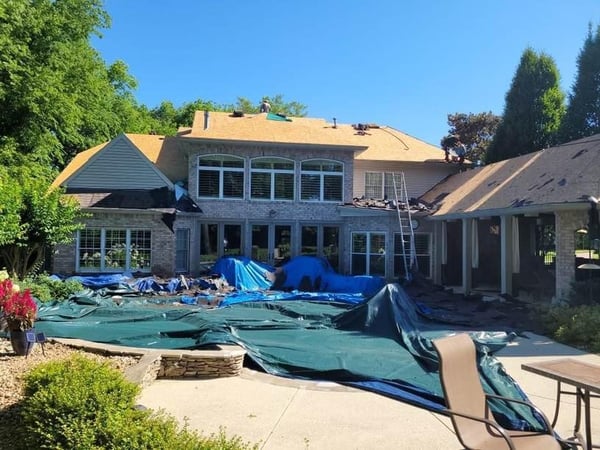 protective tarps over pool and property during roof replacement