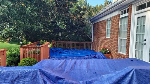 tarps covering decking to protect it during a roof replacement