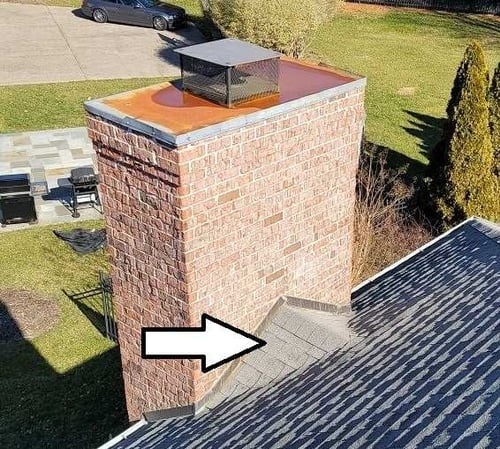 brick chimney with a asphalt shingle cricket
