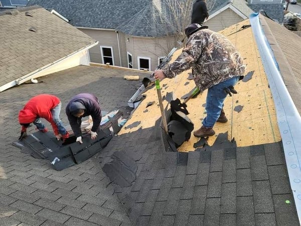roofers tearing off old asphalt shingle roof