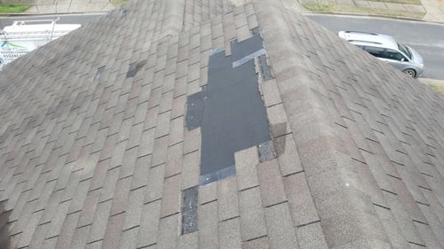 missing shingles caused by wind damage on a 3 tab asphalt shingle roof