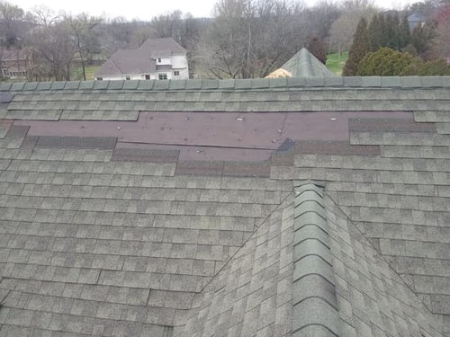 missing asphalt shingles caused by wind damage