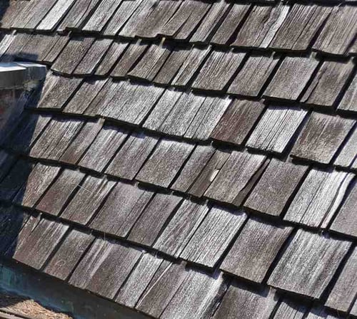 aged cedar shake shingles that have been affected by wear and tear from the weather